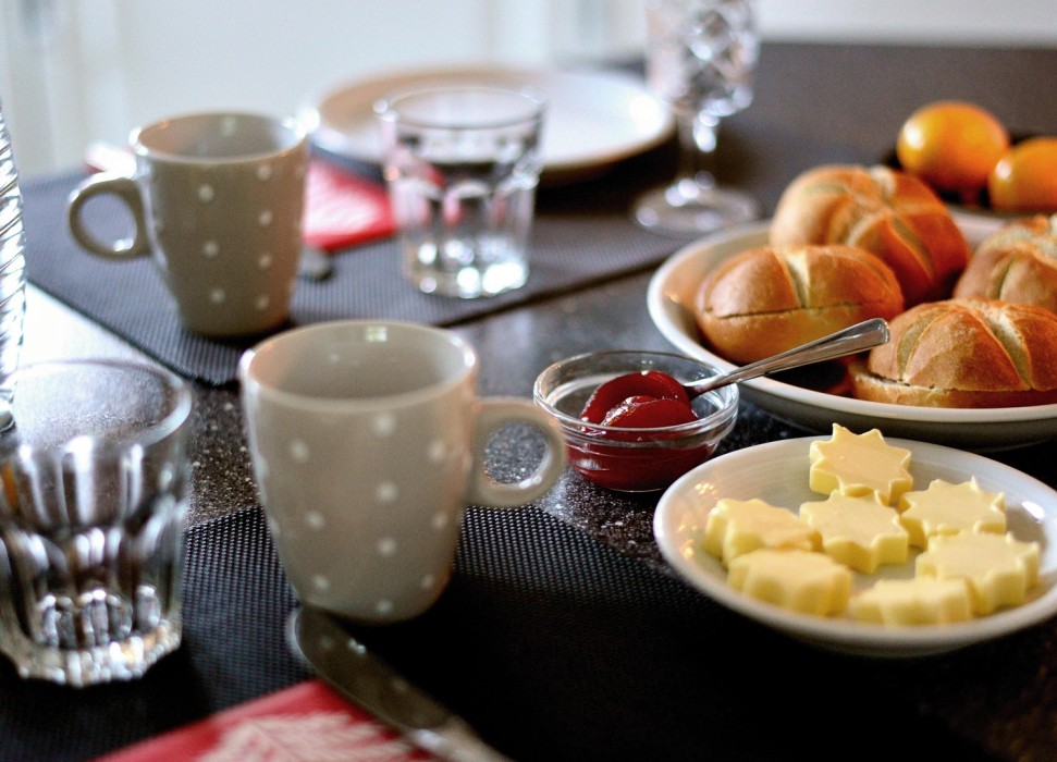 Frühstückstisch mit Brötchen, Butter und Getränken