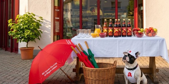 Ein Tisch mit Säften und Gläsern mit Apotheken Hund Leopold vor der Linden-Apotheke