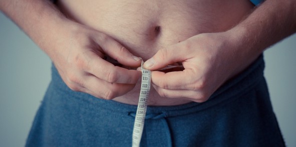 Bauch eines Mannes mit Maßband
